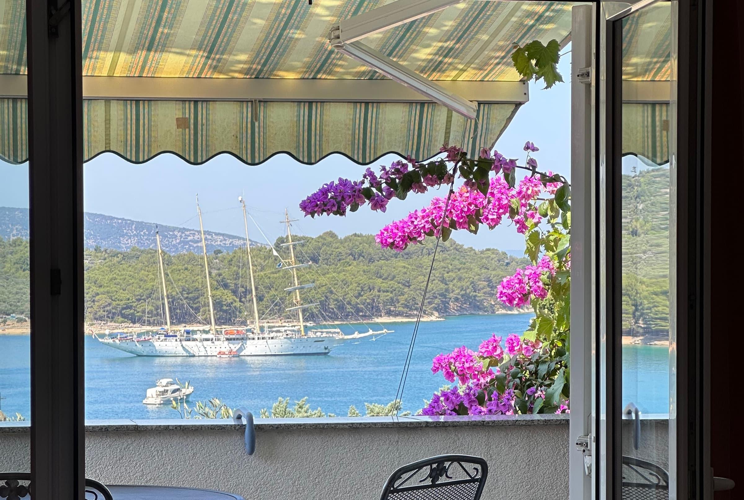 Pogled s terase na creski zaljev i veliki jedrenjak